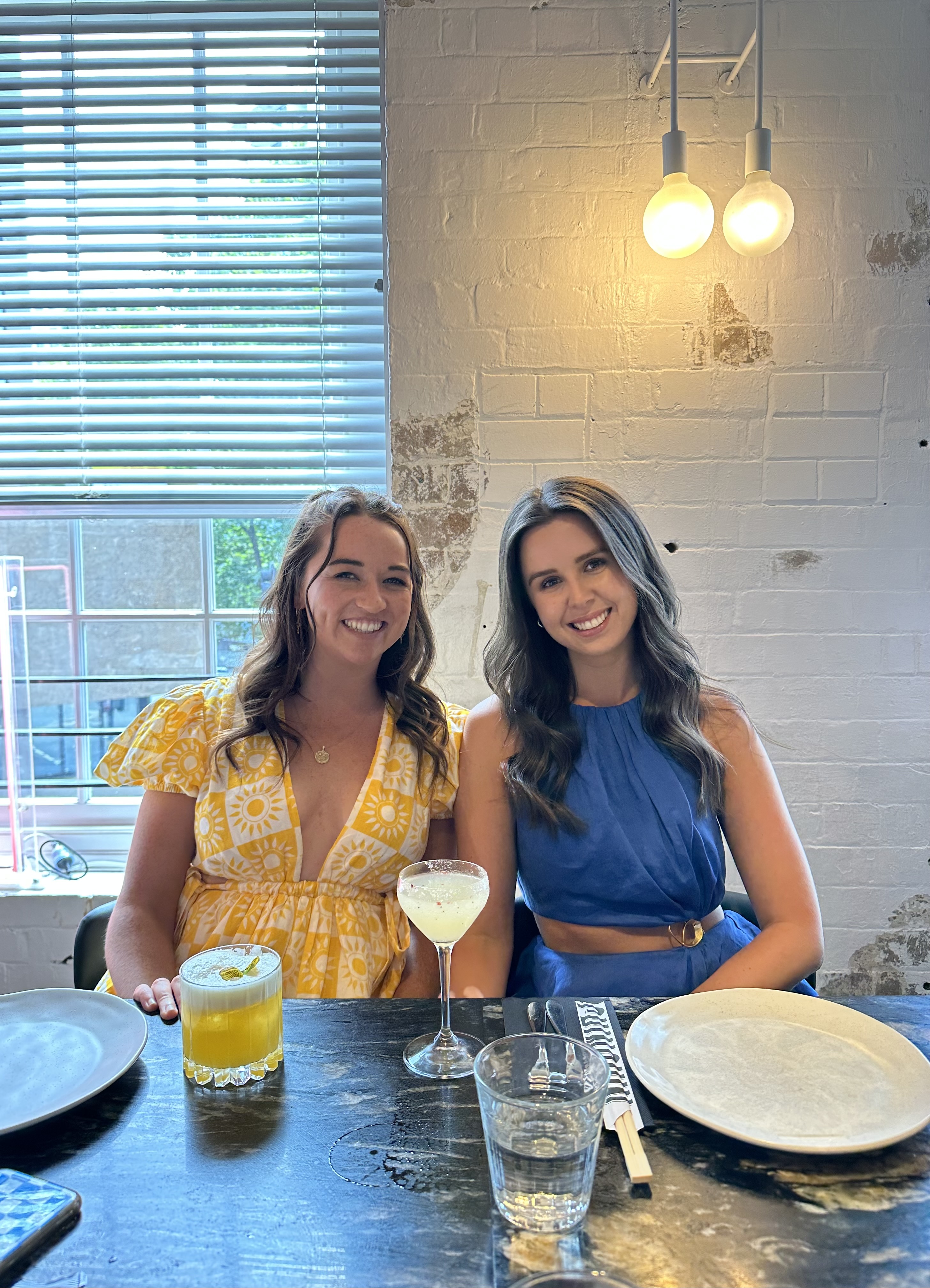 Georgia Nash, a HOKA Runaway Sydney Half Marathon fundraiser, sits next to her friend at a restaurant.
